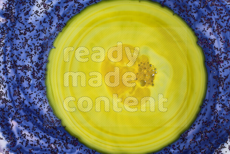 لقطة مقربة لبريق أرجواني متلألئ منتشر على خلفية من اللون الأزرق والأصفر في حركات دائرية