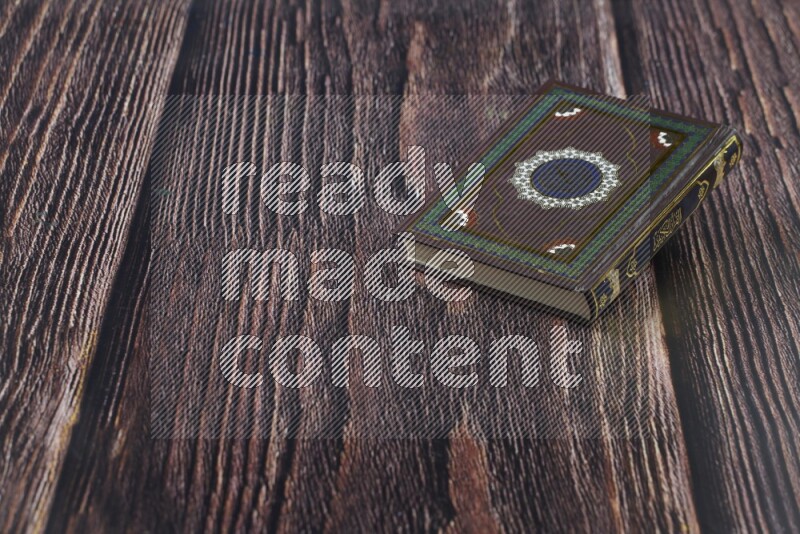 Quran with a prayer beads on wooden background