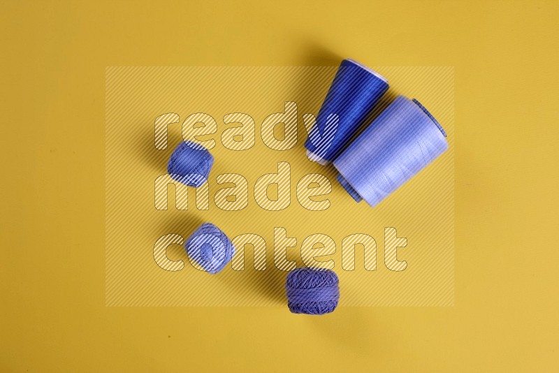 Blue sewing supplies on yellow background
