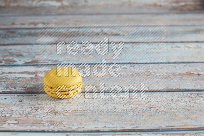 45º Shot of Yellow Lemon macaron on light blue wooden background