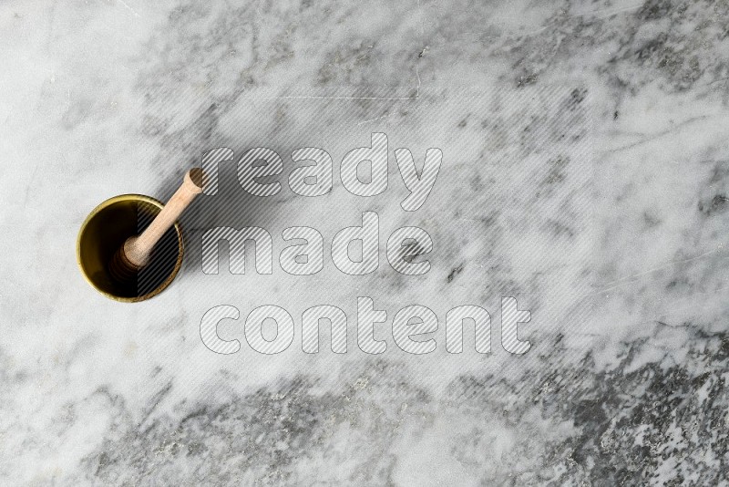 Multicolored Pottery Cup with wooden honey handle in it, on grey marble flooring, Top View