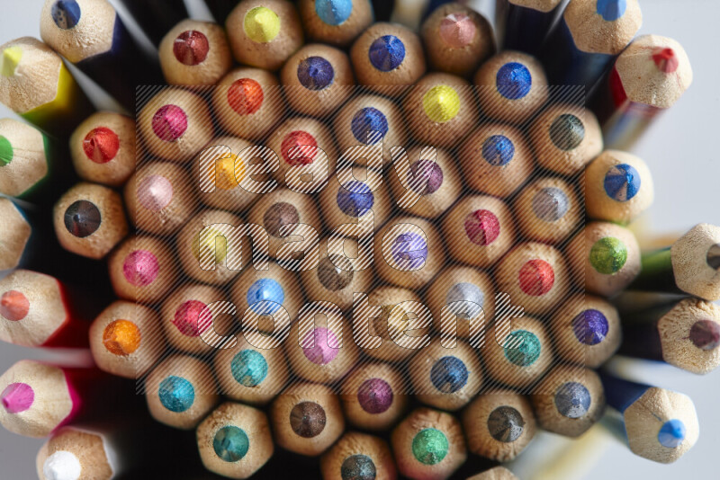 تظهر الصورة لقطة علوية لأقلام تلوين خشبية علي خلفية رمادية