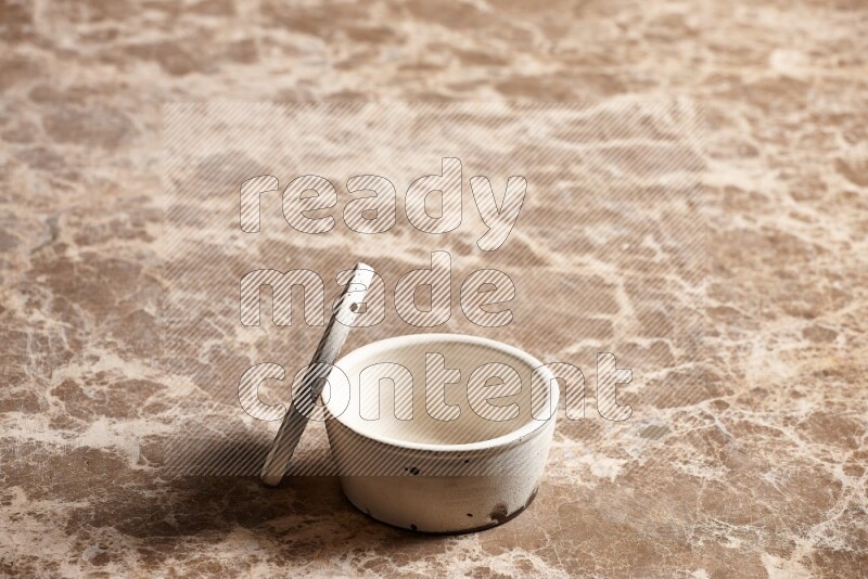 A white pottery bowl on beige marble background