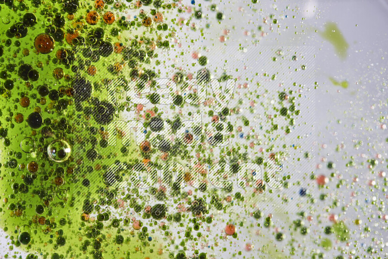 Close-ups of abstract green and red watercolor drops on oil Surface on white background