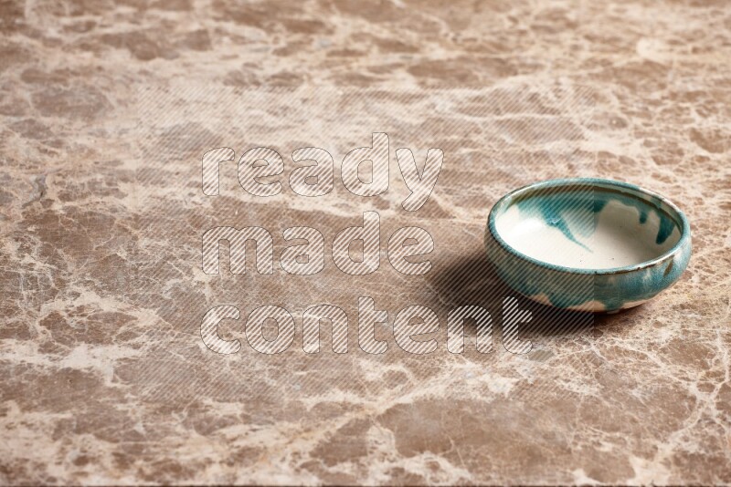 A multicolored pottery plate on beige marble background