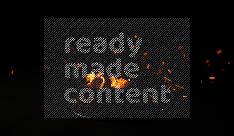 Coal cubes on fire in metal pan