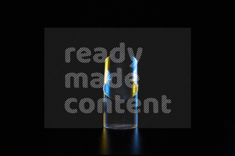 Glassware with rim light in blue and yellow against black background