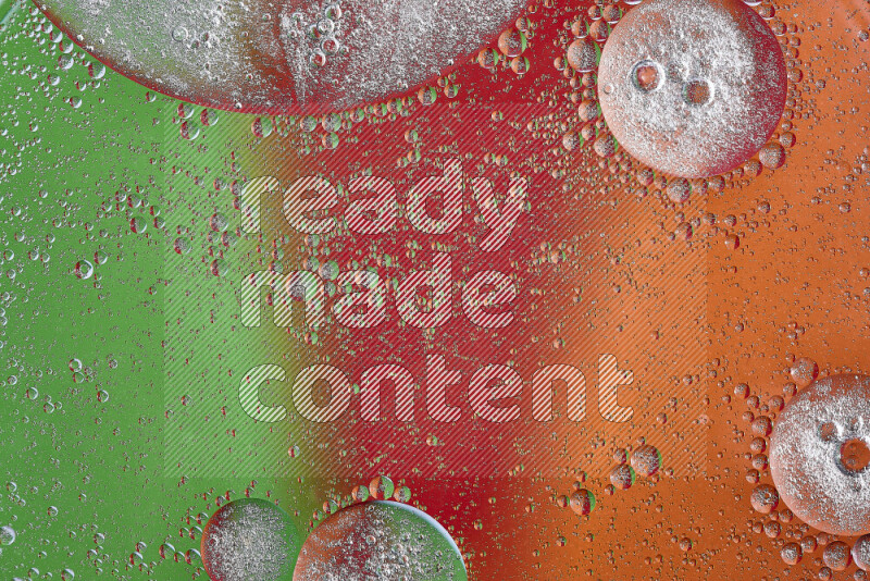 Close-ups of abstract oil bubbles on water surface in shades of orange, green and red