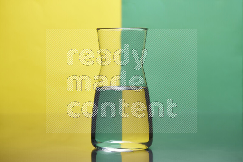 تظهر الصورة أواني زجاجية ممتلئة بالماء موضوعة على خلفية من اللونين الأصفر والأخضر