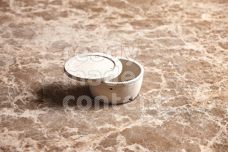 White Pottery Bowl on Beige Marble Flooring, 45 degrees