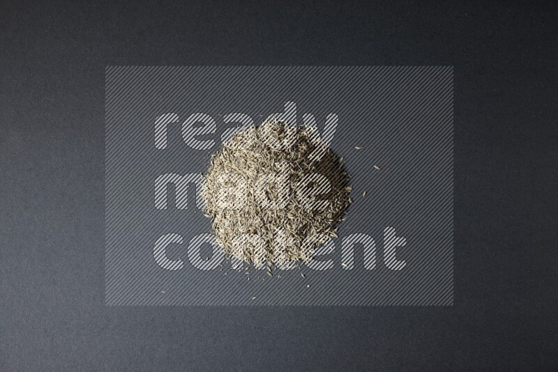 Cumin seeds on black flooring