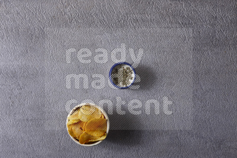 وجبات خفيفة متنوعة في أوعية فخارية على خلفية رمادية