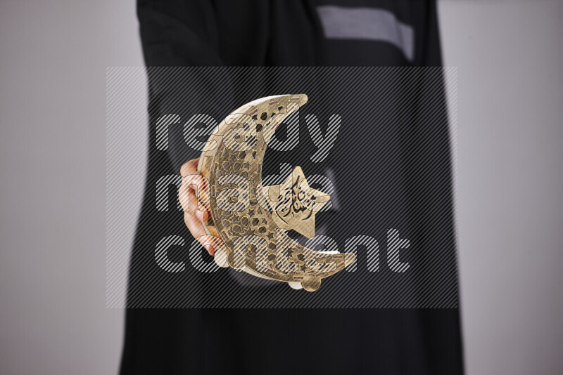 امرأة ترتدي عباءة سوداء تحمل فوانيس رمضانية مختلفة في أوضاع متعددة