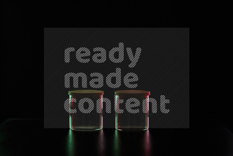 Glassware with rim light in red and green against black background