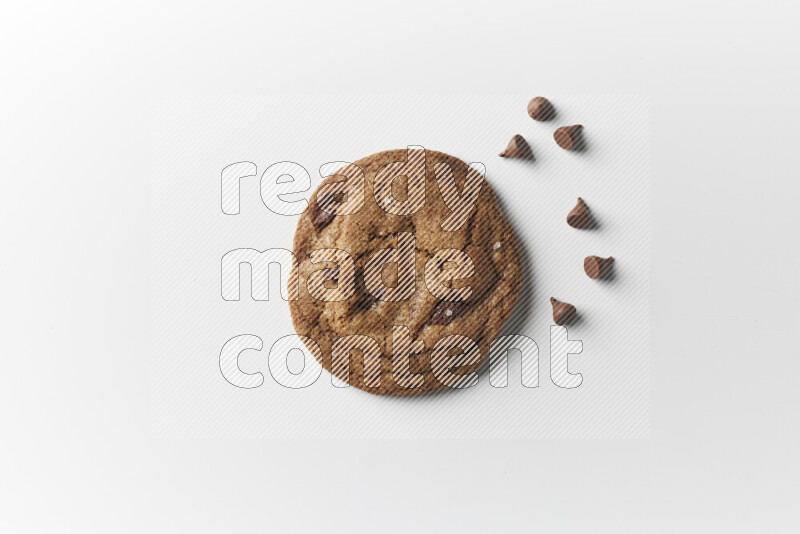 A single chocolate chips cookie with chocolate beside it on a white background