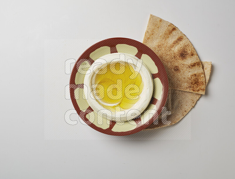 Lebnah garnished with olive oil in a traditional plate on a white background