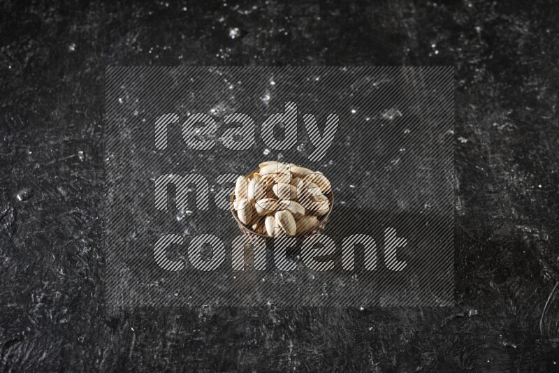 مكسرات في وعاء معدني علي خلفية سوداء