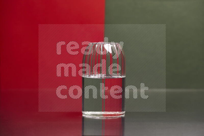 The image features a clear glassware filled with water, set against red and dark green background