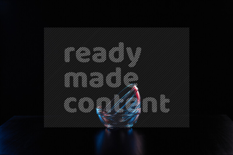 Glassware with rim light in red and blue against black background