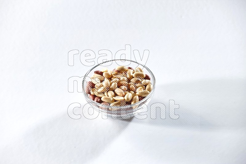 A glass bowl full of peeled peanuts on a white background in different angles