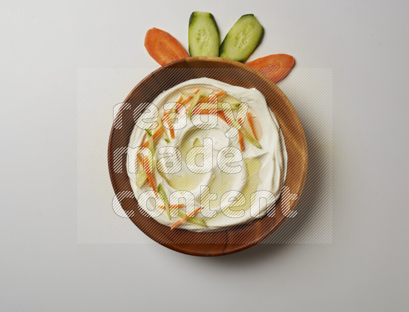 Lebnah garnished with sliced carrots & cucumber in a wooden plate on a white background
