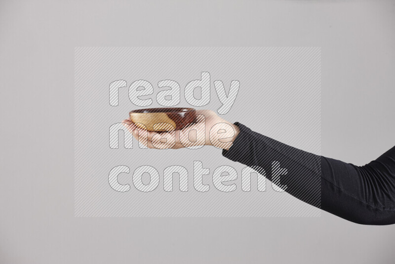 A woman in black abaya holding different wooden essentials in different positions