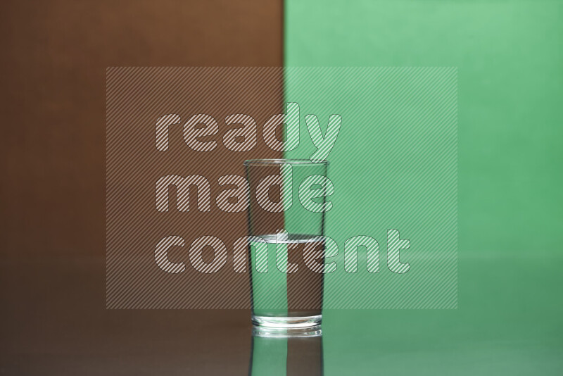 The image features a clear glassware filled with water, set against brown and green background