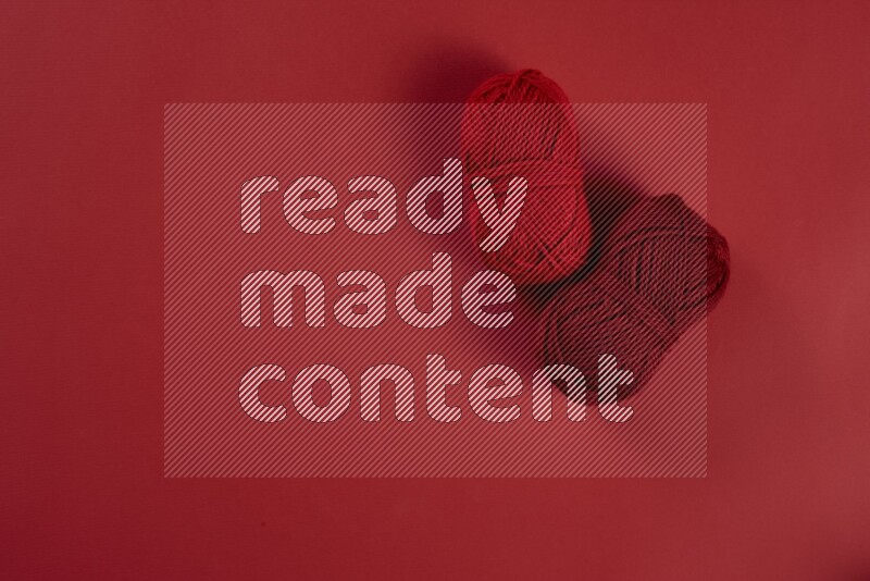 مجموعة من أدوات الخياطة والتفصيل حمراء اللون على خلفية حمراء