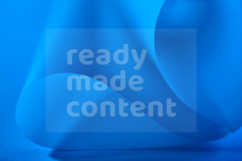 An abstract art piece displaying smooth curves in blue gradients created by colored light