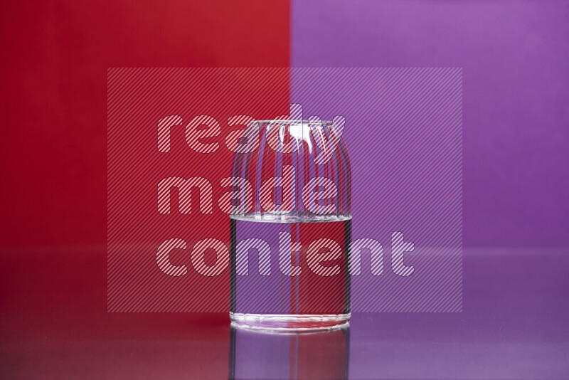 The image features a clear glassware filled with water, set against red and purple background