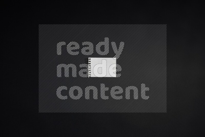 Folded notebook sheet on black background