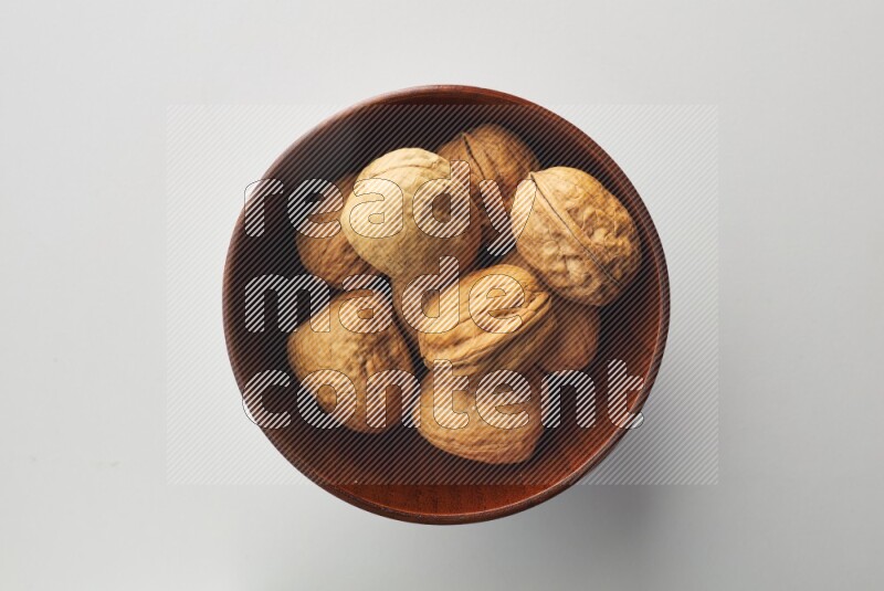Top-view shot of walnut in a container on white background