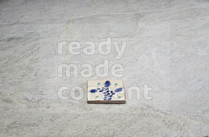 Top view shot of a pottery coaster\ tile on beige marble flooring