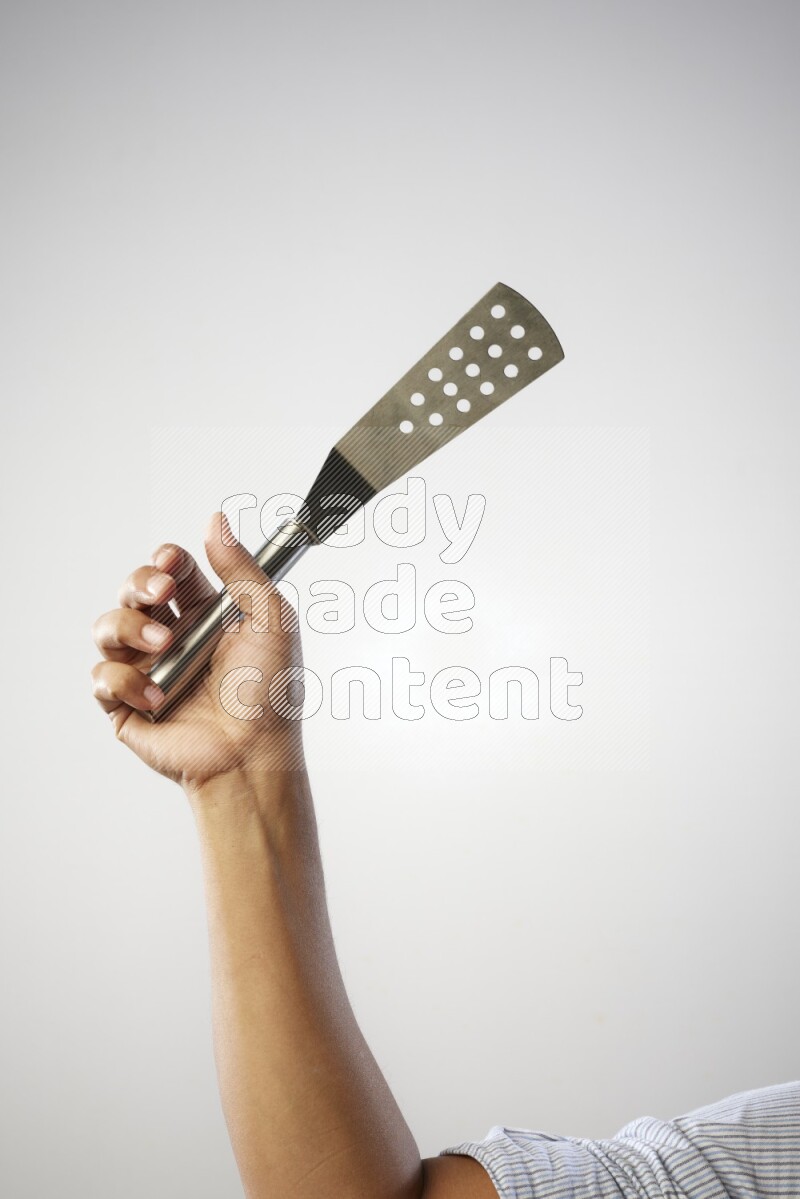 Male Hand Holding Burger Flipper on white background