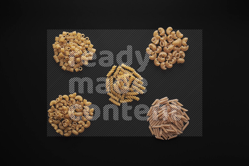 Different pasta types in bunches on black background