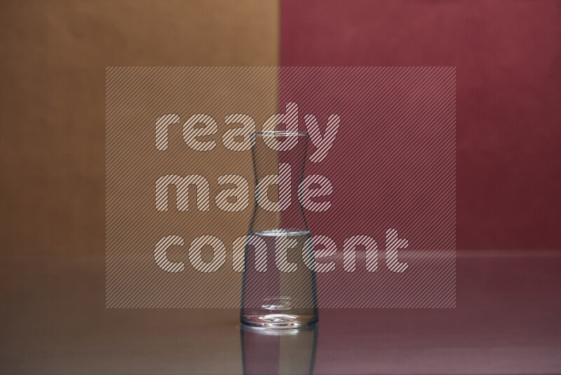 The image features a clear glassware filled with water, set against brown and dark red background