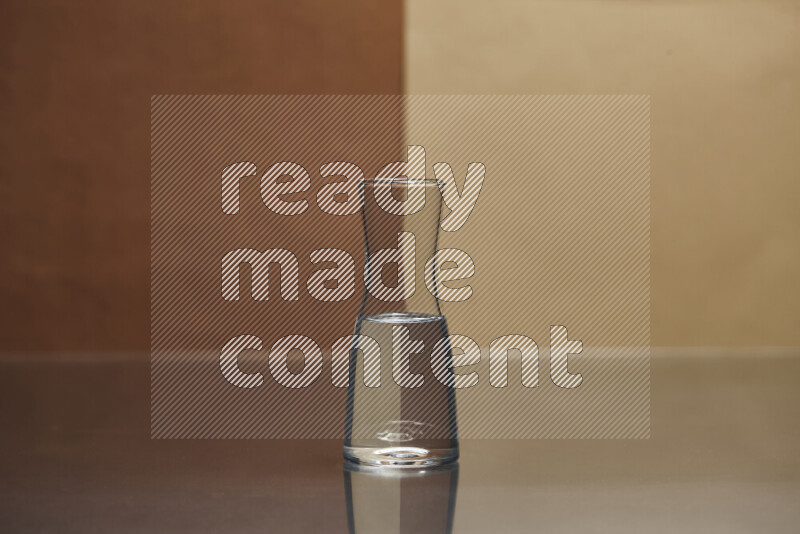 The image features a clear glassware filled with water, set against brown and beige background