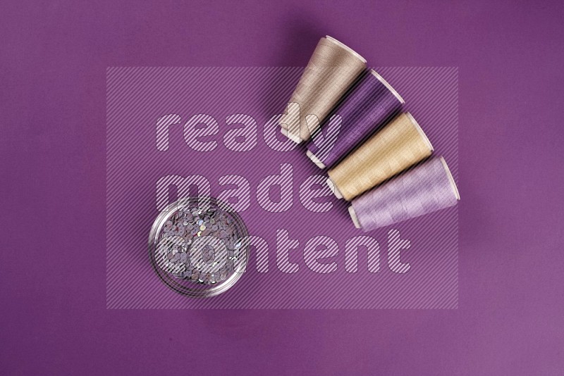 Beige sewing supplies on purple background