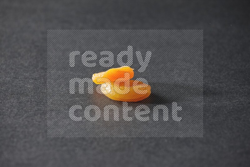 حبتان من المشمش المجفف على خلفية سوداء