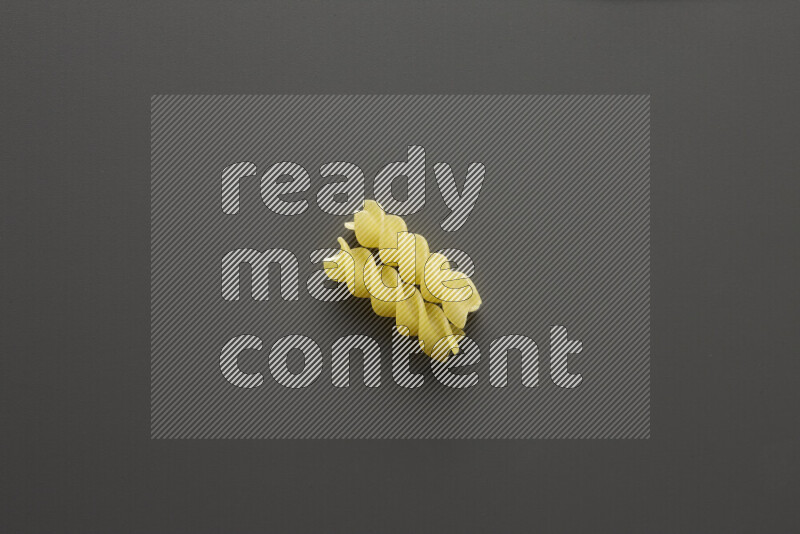 Fusilli pasta on grey background