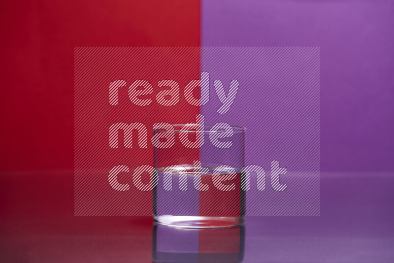 The image features a clear glassware filled with water, set against red and purple background