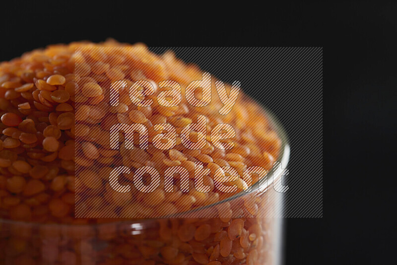 Lentils in a glass jar on black background