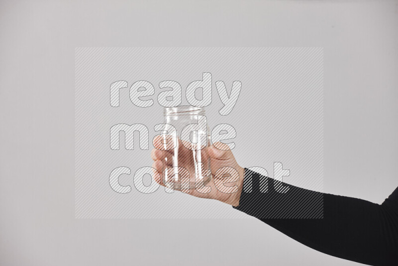 A woman in black abaya holding different glassware in different positions