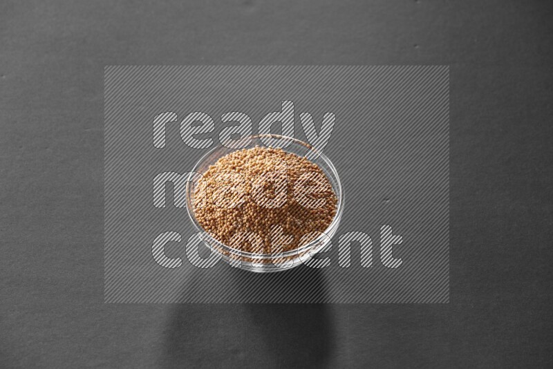 حبوب الخردل في وعاء زجاجي علي خلفية سوداء