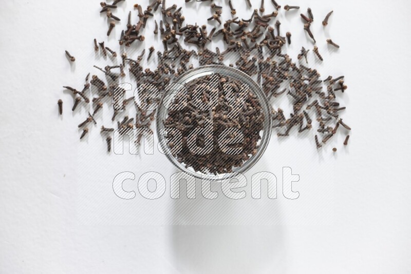 وعاء زجاجي ممتلئ بالقرنفل على أرضية بيضاء