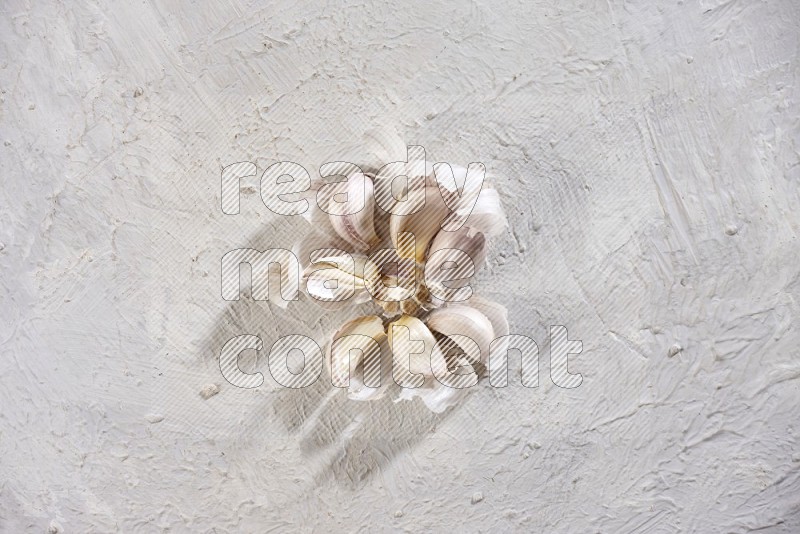 A garlic bulb shaped like flower on a textured white flooring in different angles