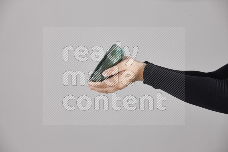 امرأة ترتدي عباءة سوداء تحمل أدوات فخارية مختلفة في أوضاع متعددة