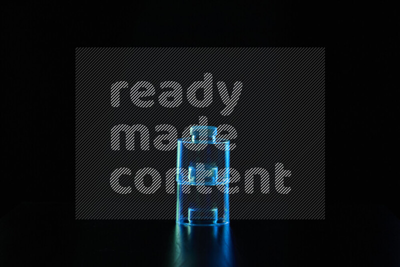 Glassware with rim light in blue and green against black background