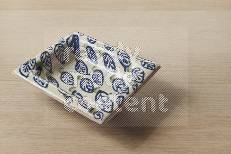 صحن فخاري مزخرف على خلفية خشبية فاتحة