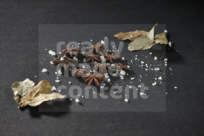 الملح واليانسون النجمي وورق الغار على خلفية سوداء